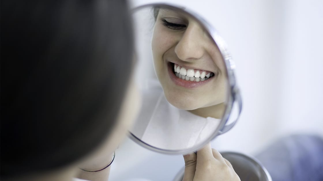 Girl Smiling in Hand Mirror