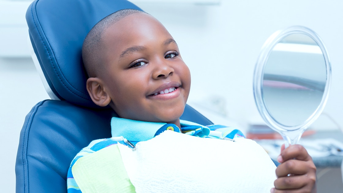 Boy in Dental Chair Holding Mirror